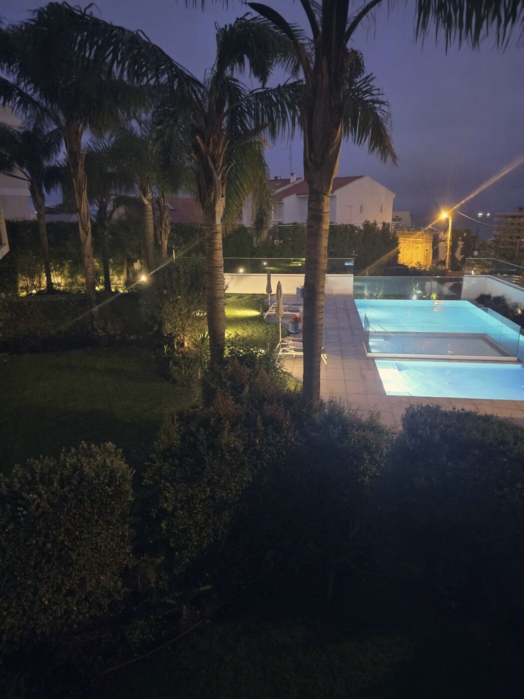 Jardim e piscina iluminados à noite